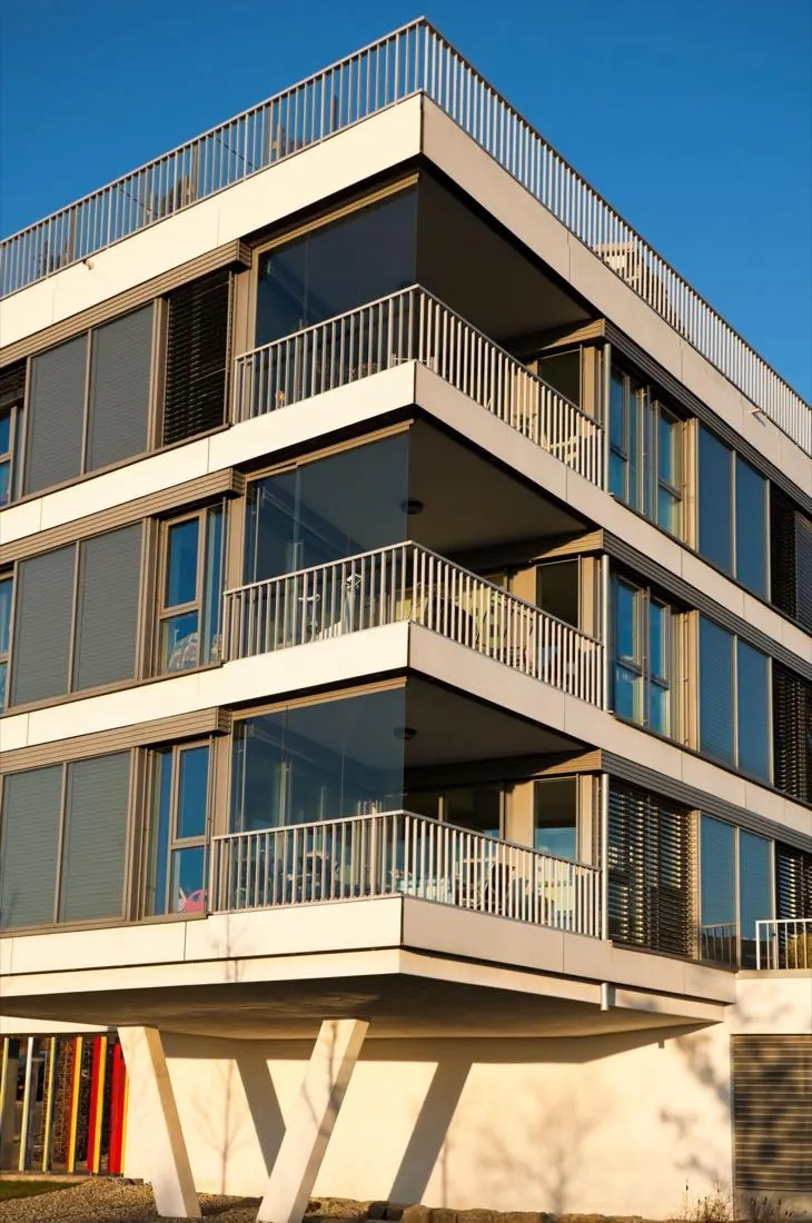 Modernes Mehrfamilienhaus mit Balkonen im Abendlicht